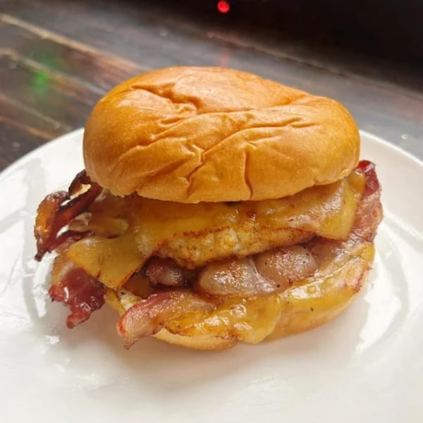Olivier Cafe's breakfast sandwich with bacon, egg, and melted cheese on a brioche bun.